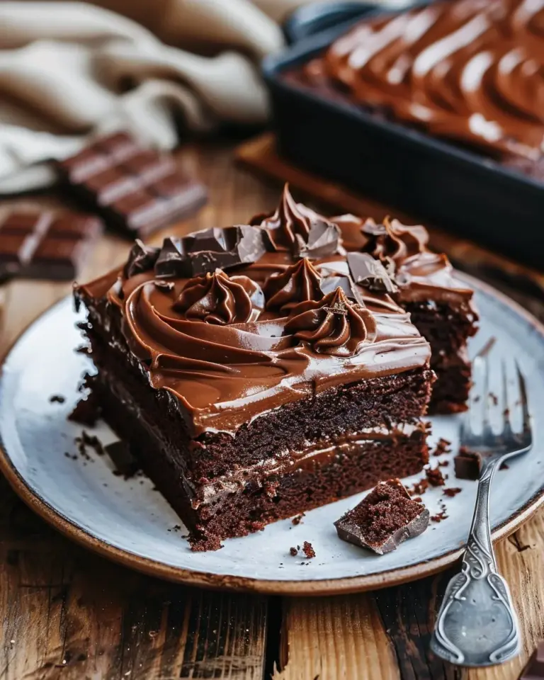 Moist chocolate sheet cake topped with whipped cream and chocolate ganache.